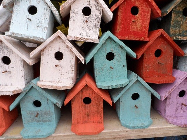 Multiple Birdhouses Of Different Colors Stacked Neatly On Top Of Each Other Photo